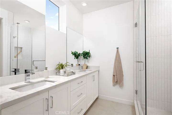 Model home primary bath with natural light and dual vanity sinks