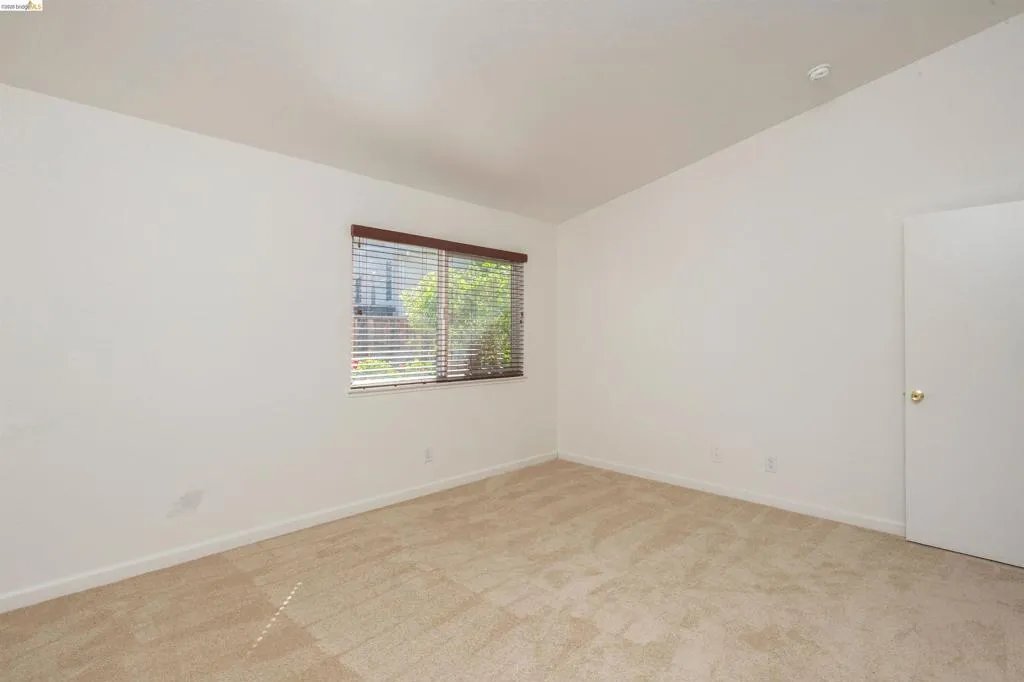 Room with neutral-toned carpeting and white walls