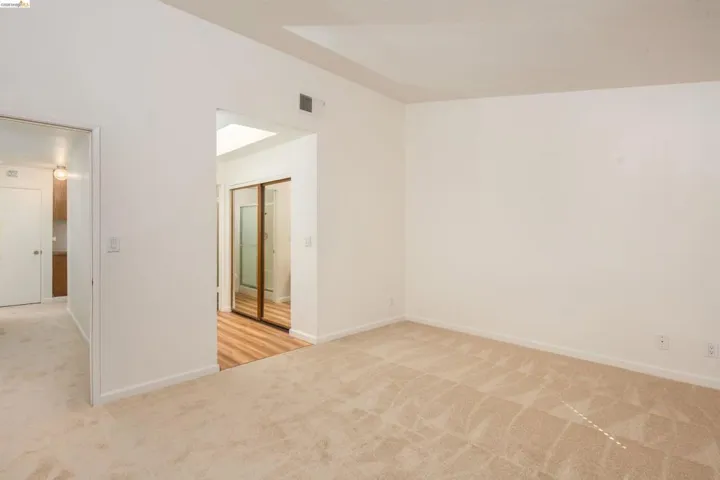 Spacious room featuring neutral carpeting and white walls