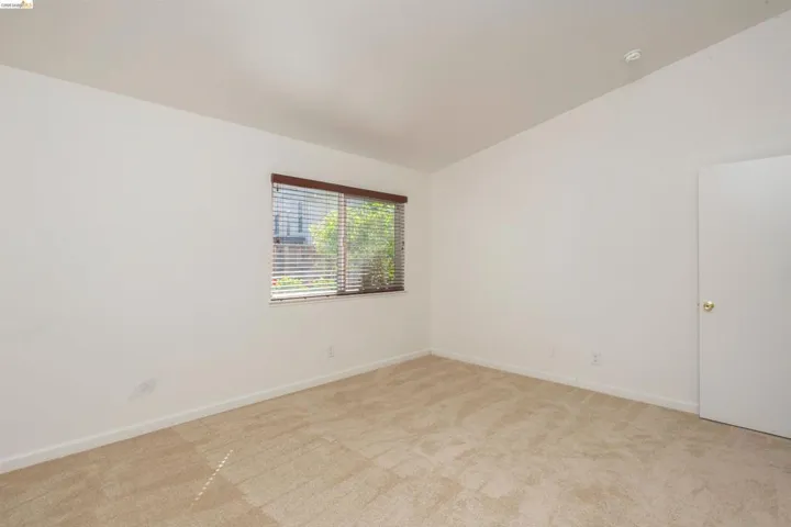 Room with neutral-toned carpeting and white walls