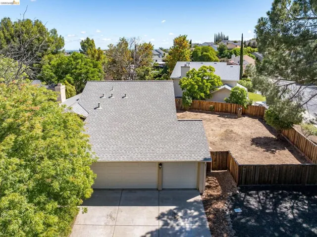 Property featuring a two-car garage, concrete driveway, and a fenced backyard
