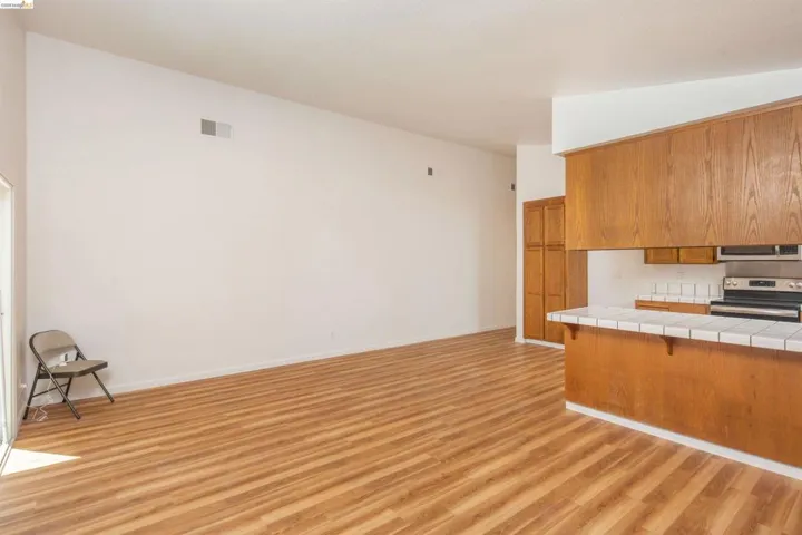 Open concept living area featuring wood-finish flooring and vaulted ceilings