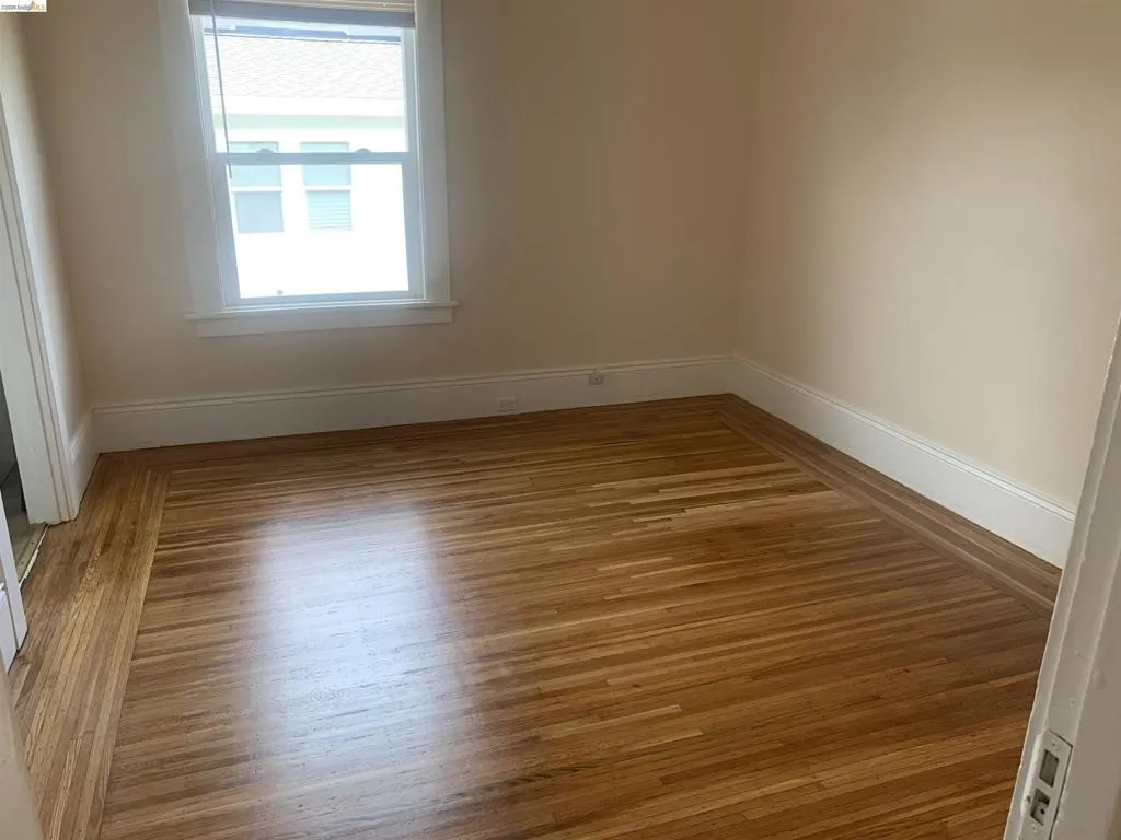 Empty room with baseboards and wood finished floors