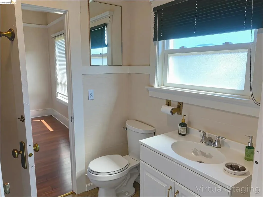 Half bath featuring vanity and wood finished floors