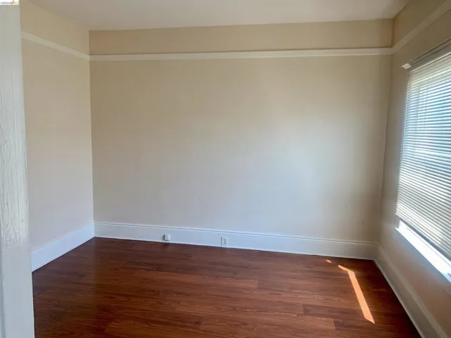 Empty room with baseboards and dark wood-style flooring