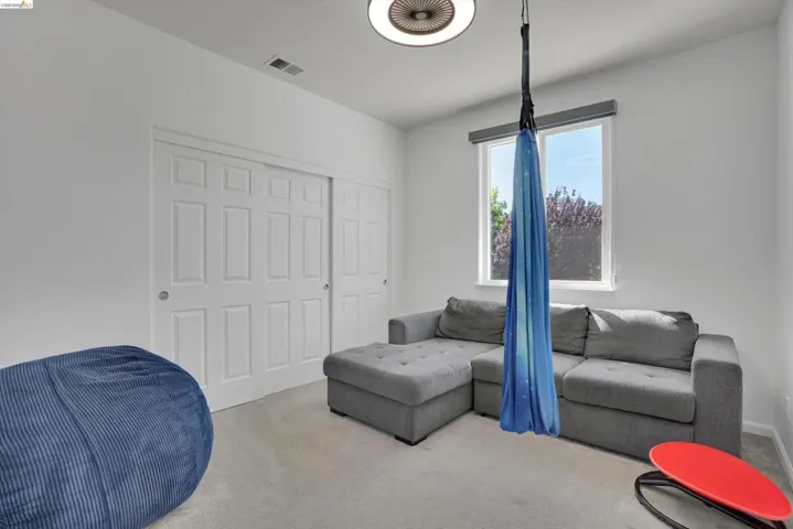 Room featuring neutral wall tones, light-colored carpeting, and a window with a roller shade
