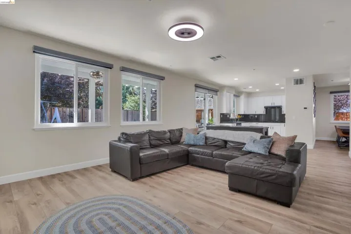 Open concept living area featuring wood-finish flooring and multiple windows