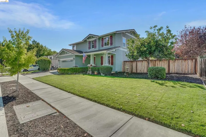 Two-story residence featuring a light gray exterior, dark roof, and red decorative shutters