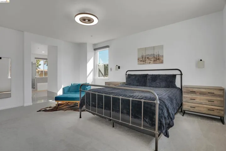 Spacious room featuring light gray carpeting and white walls