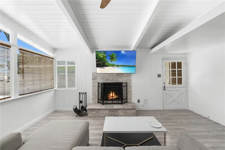 living room with wood beamed vaulted ceilings