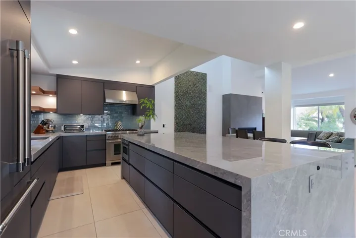 Open kitchen design with direct sightlines to living and dining areas