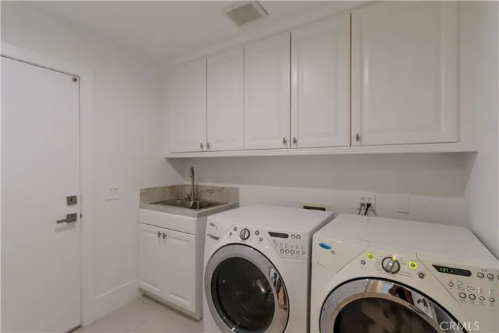 Functional laundry room with built-in cabinetry and utility sink