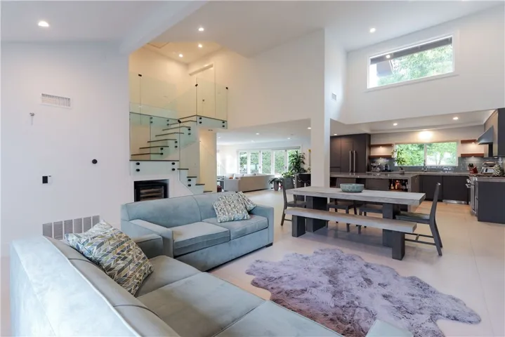 Light-filled entry with soaring ceilings and modern glass staircase