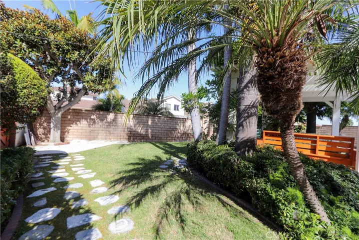 Charming garden pathway and grassy area offer additional space to relax or play