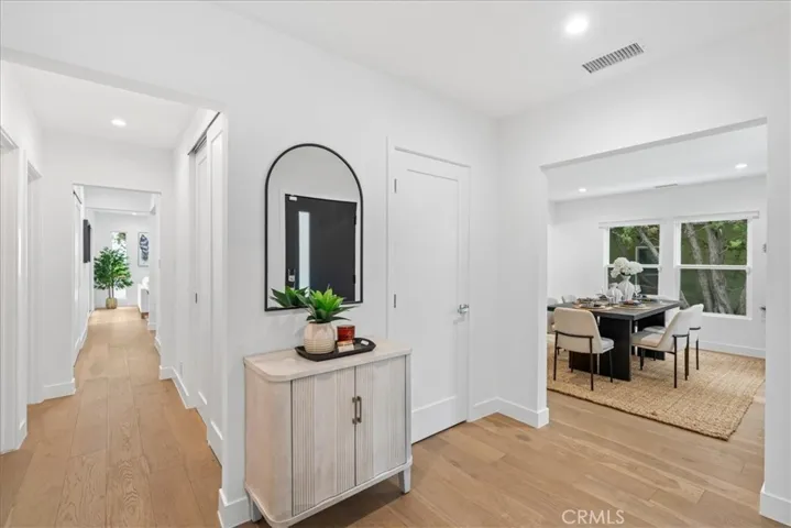 Foyer showcasing new hardwood flooring leading to living room, dining room, and first floor hallway