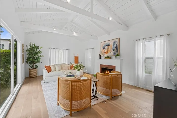 Spacious living room with large windows, vaulted ceiling, and fireplace