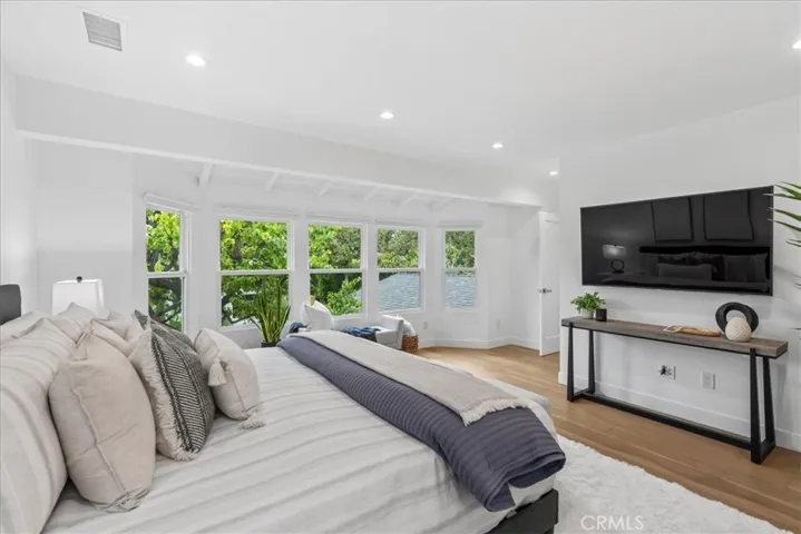 Primary Bedroom with expansive windows looking out to the front shady tree
