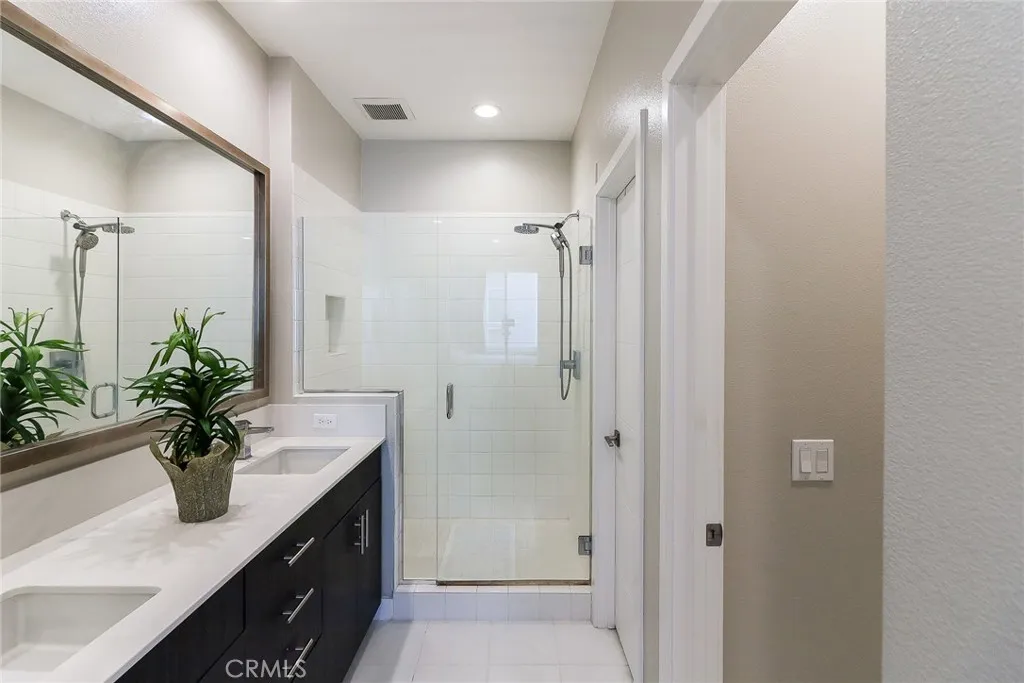 3rd floor main bath, double sink, modern shower. to the left is the walk in close and separate toilet