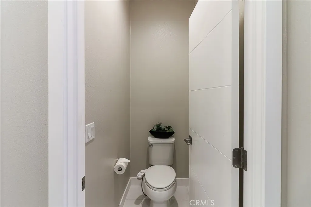 The main bathroom's toilet area, which features a private door for added seclusion, ensuring it is completely separate from the shower and sink areas, offering both privacy and functionality within the space.