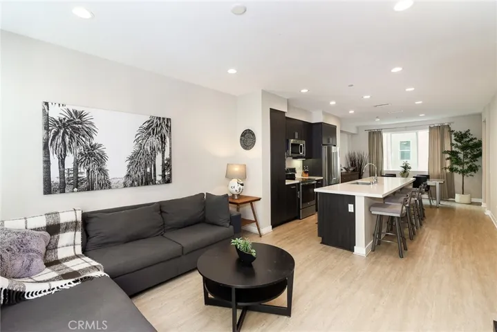 Notice the open layout, creating a seamless flow between the living area, the adjacent kitchen, and the dining room, making it an ideal space for both daily living and entertaining.