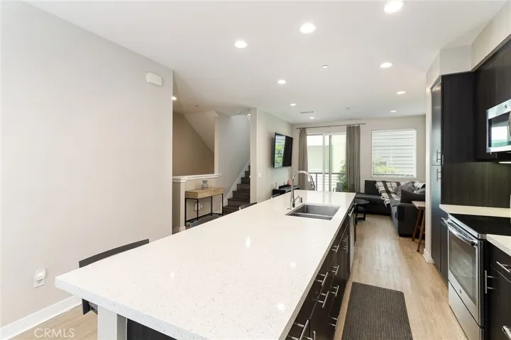 Note the stairs tot he 3rd floor, the veranda outside of the living room and of course, the good-sized kitchen island!
