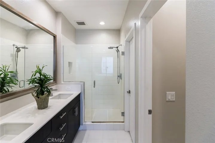 3rd floor main bath, double sink, modern shower. to the left is the walk in close and separate toilet