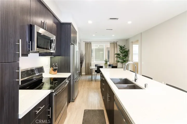 This kitchen overlooks the dining room! A seamless flow of entertaining and meals! Note the fine cabinetry design and stainless steel appliances!