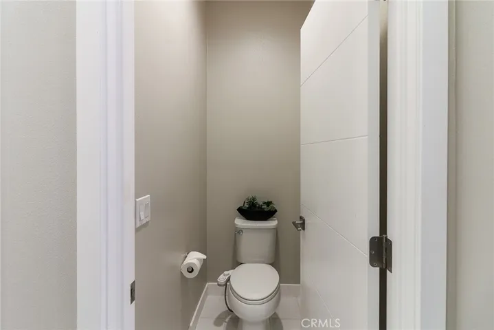 The main bathroom's toilet area, which features a private door for added seclusion, ensuring it is completely separate from the shower and sink areas, offering both privacy and functionality within the space.