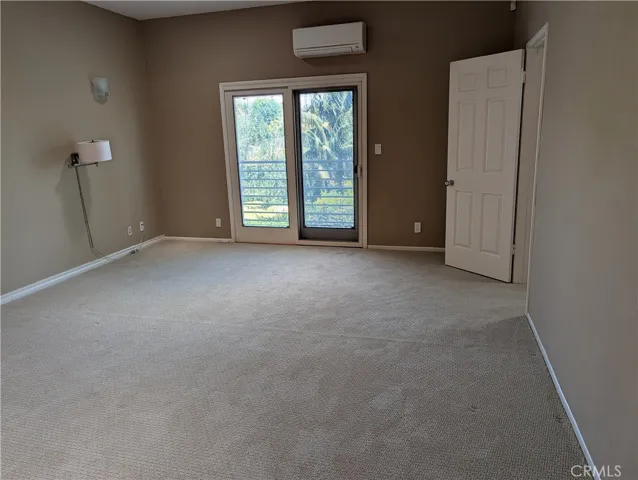 Primary bedroom with balcony and walk-in closet