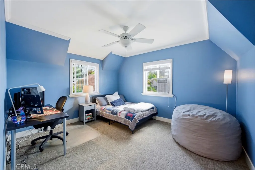 Bedroom 4 with a fun blue color, carpet and angled ceiling.