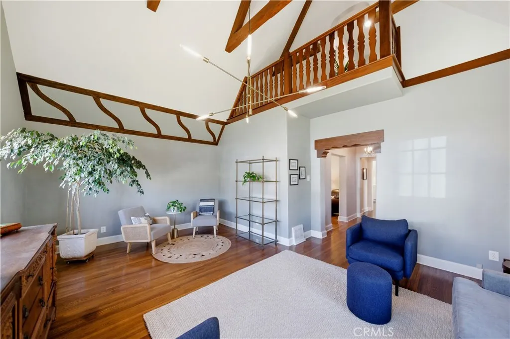 Living room is enhanced by a soaring ceiling and intricate wood work.