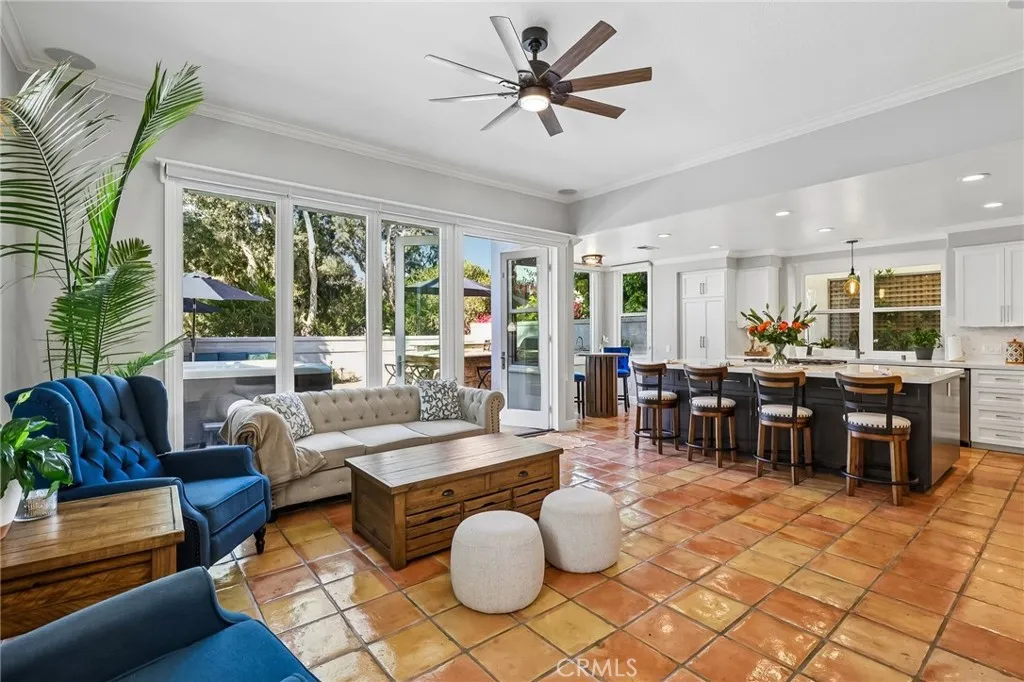 The Great Room opens to the Kitchen and Backyard. It features glowing Saltio tile flooring, ceiling height windows and French Doors.