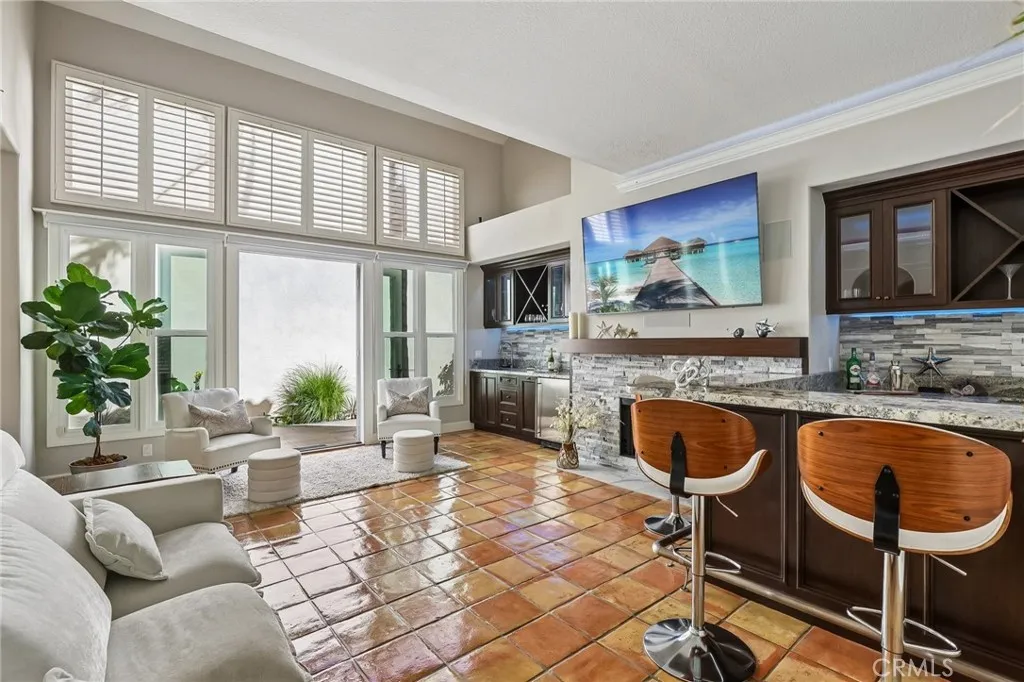 The Entertainment Room features a wine bar with fridge and icemaker, custom cabinets and granite surfaces.