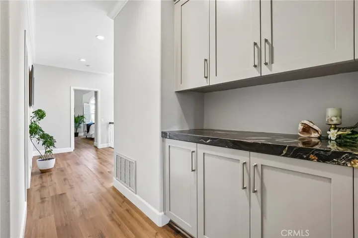 Hallway to the guest area includes linen storage cabinets with granite counter