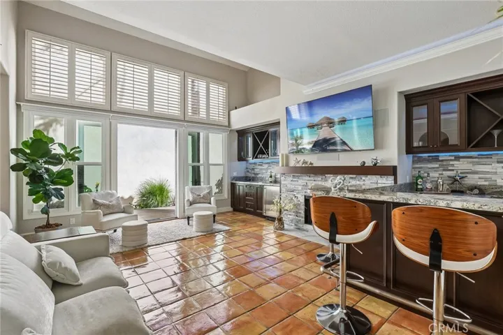 The Entertainment Room features a wine bar with fridge and icemaker, custom cabinets and granite surfaces.