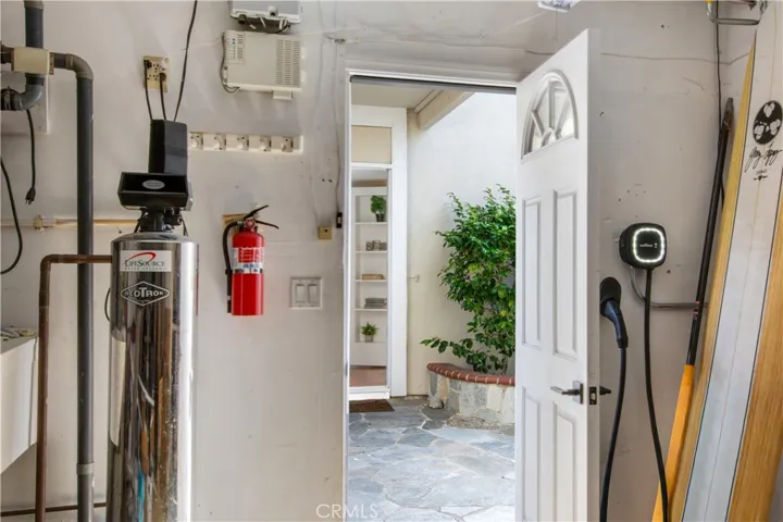 Garage entry from patio including filtered water system and electric vehicle plug in excluding Tesla.