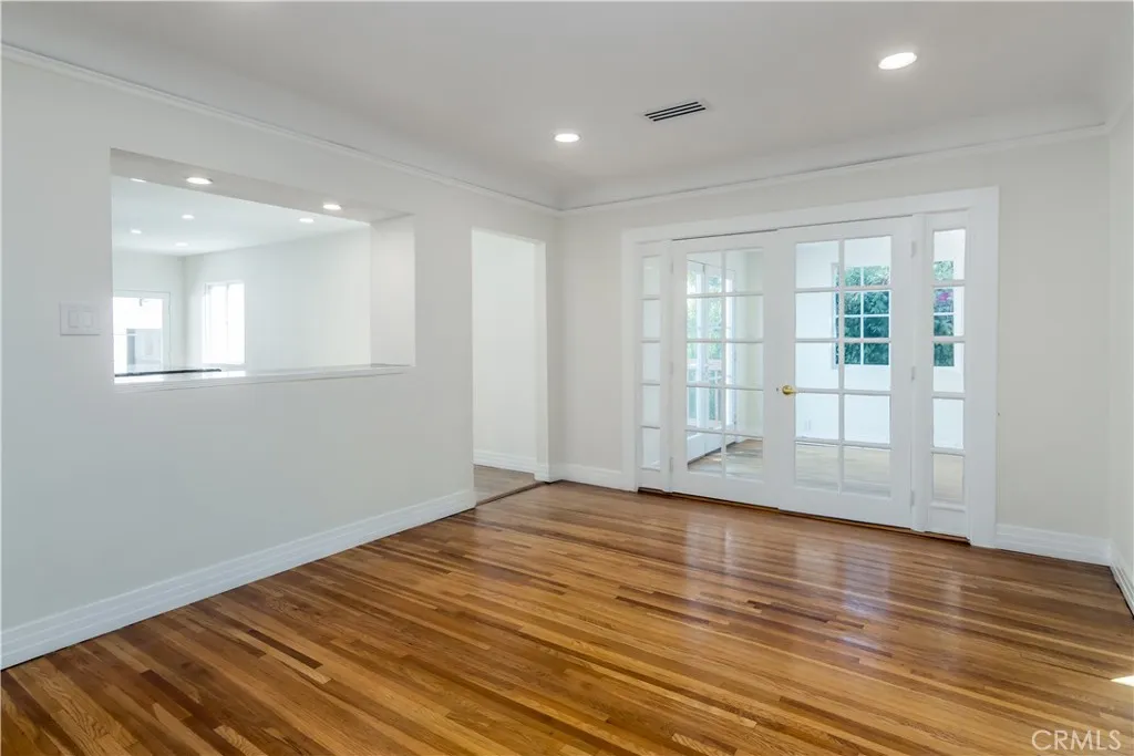 Dining room with French doors to sunroom and outdoor deck.  Kitchen to the left with pass-through opening