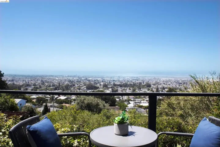 Balcony featuring a cable railing system and expansive city and water scenery