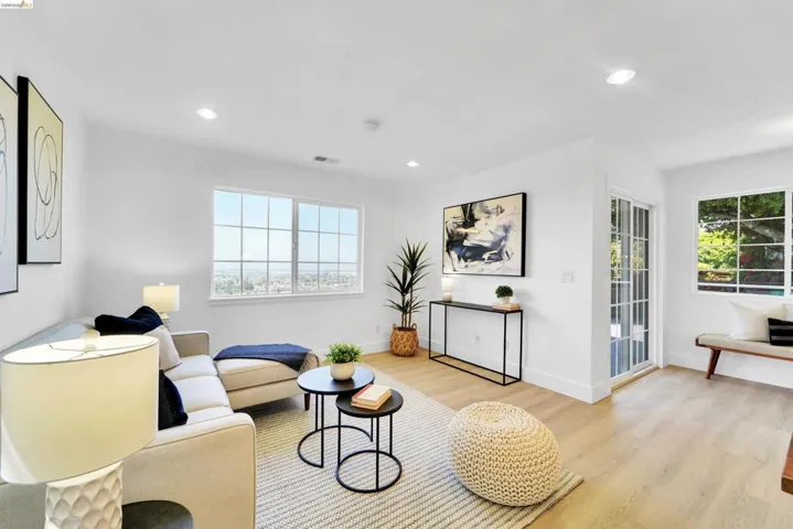 Bright living area featuring wood-finish flooring, recessed lighting, and white baseboards