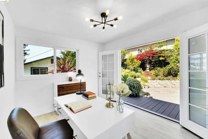 Indoor-outdoor room featuring light wood-finish flooring, white walls, and a modern ceiling light fixture