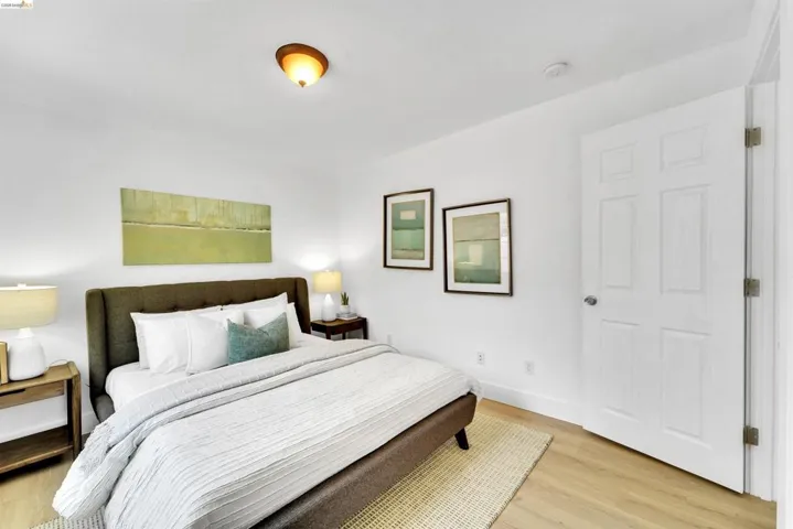Neutral color palette featuring wood-finish flooring, white baseboards, and a paneled interior door