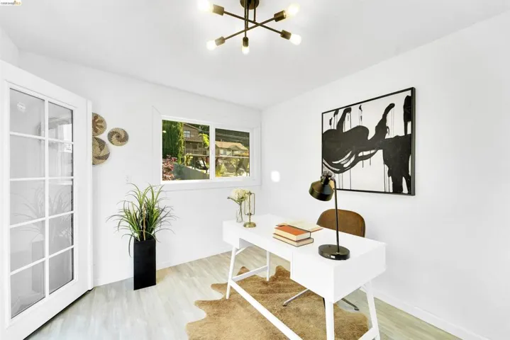 Brightly lit room featuring a contemporary ceiling fixture, white walls, and light wood-finish flooring