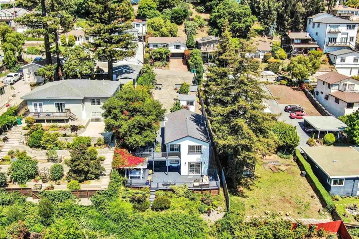 Multi-level property with a white exterior and dark roof