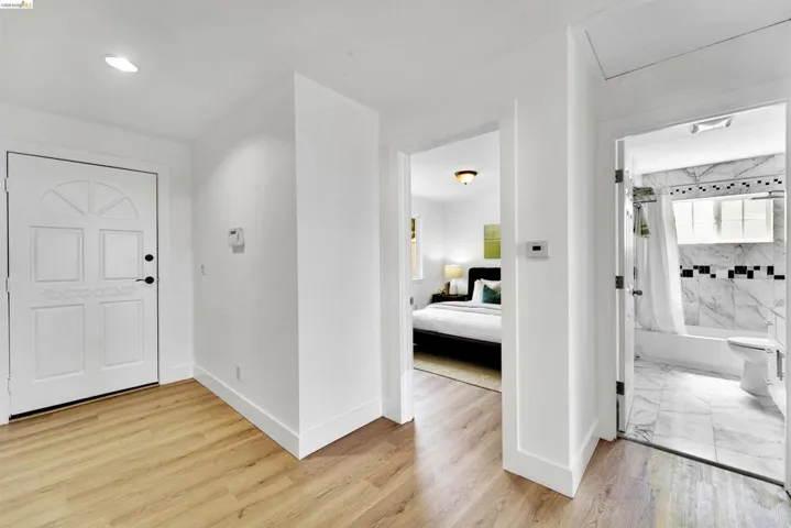 Entryway featuring light wood-finish flooring and a paneled white door