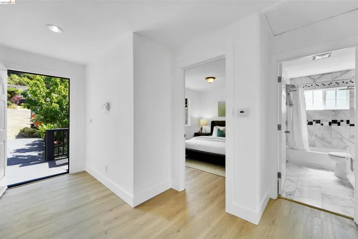 Entryway featuring wood-finish flooring, white walls, and recessed lighting