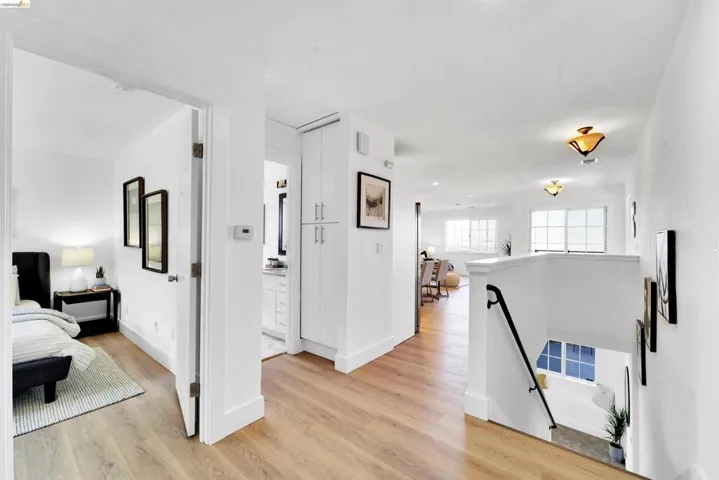 Upper-level hallway featuring wood-finish flooring, white walls, and recessed lighting