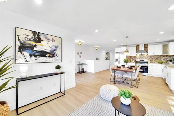 Bright open-concept living space featuring wood-finish flooring, recessed lighting, and white walls