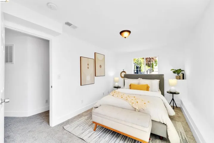 Bright bedroom featuring a single window, recessed lighting, and light gray carpeting