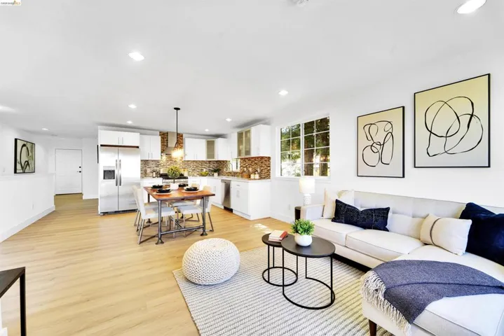Open-concept living space featuring wood-finish flooring, recessed lighting, and white walls