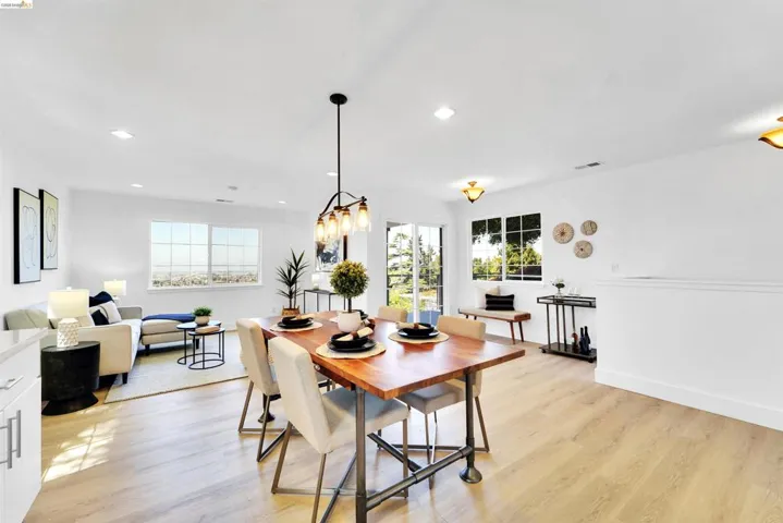 Bright open-concept living space featuring wood-finish flooring, recessed lighting, and expansive windows
